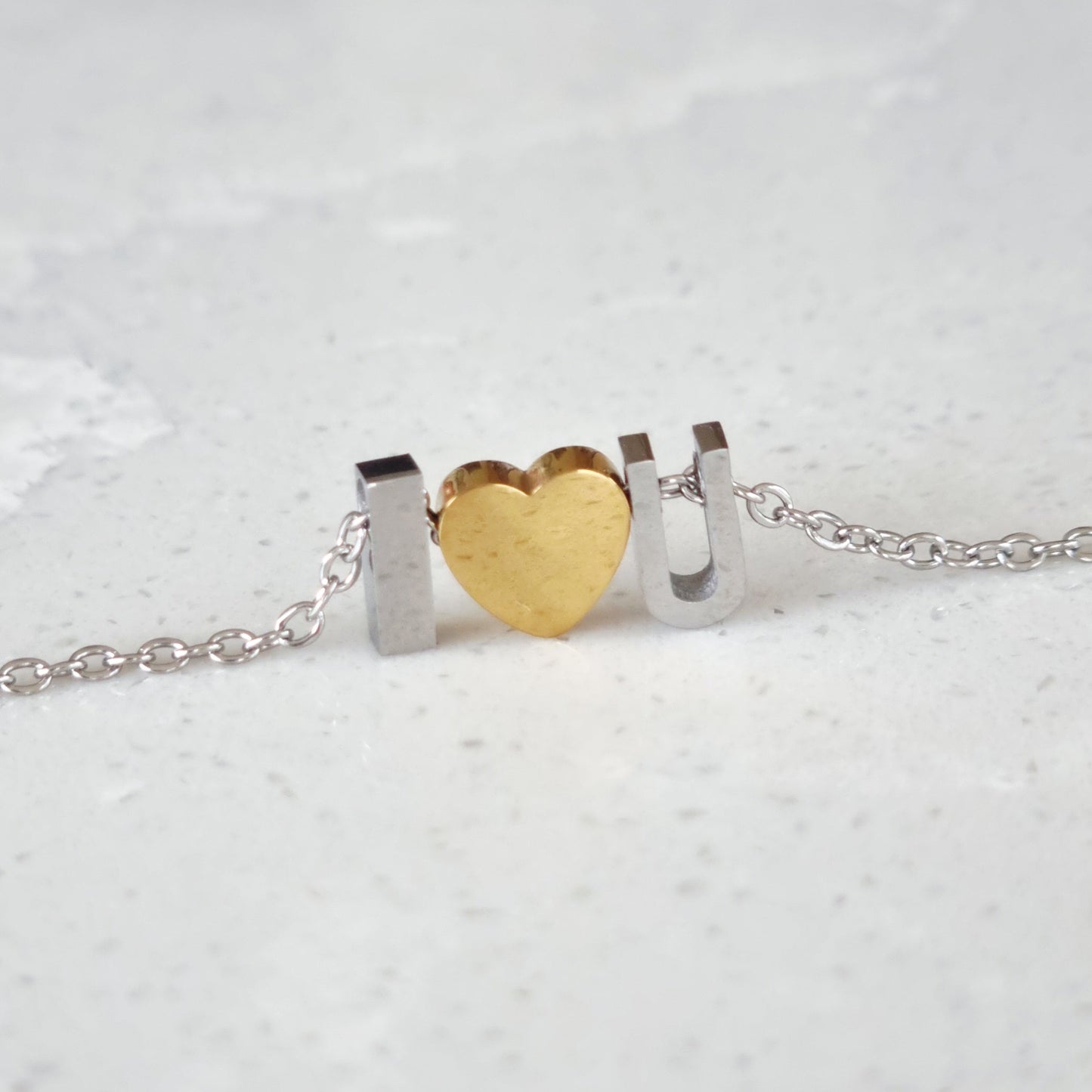 Necklace with 'I ❤️ U' on a light gray background