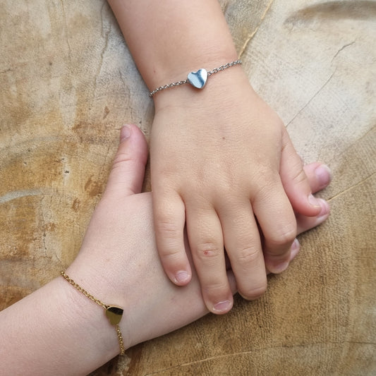 Two hands holding each other on a wooden surface