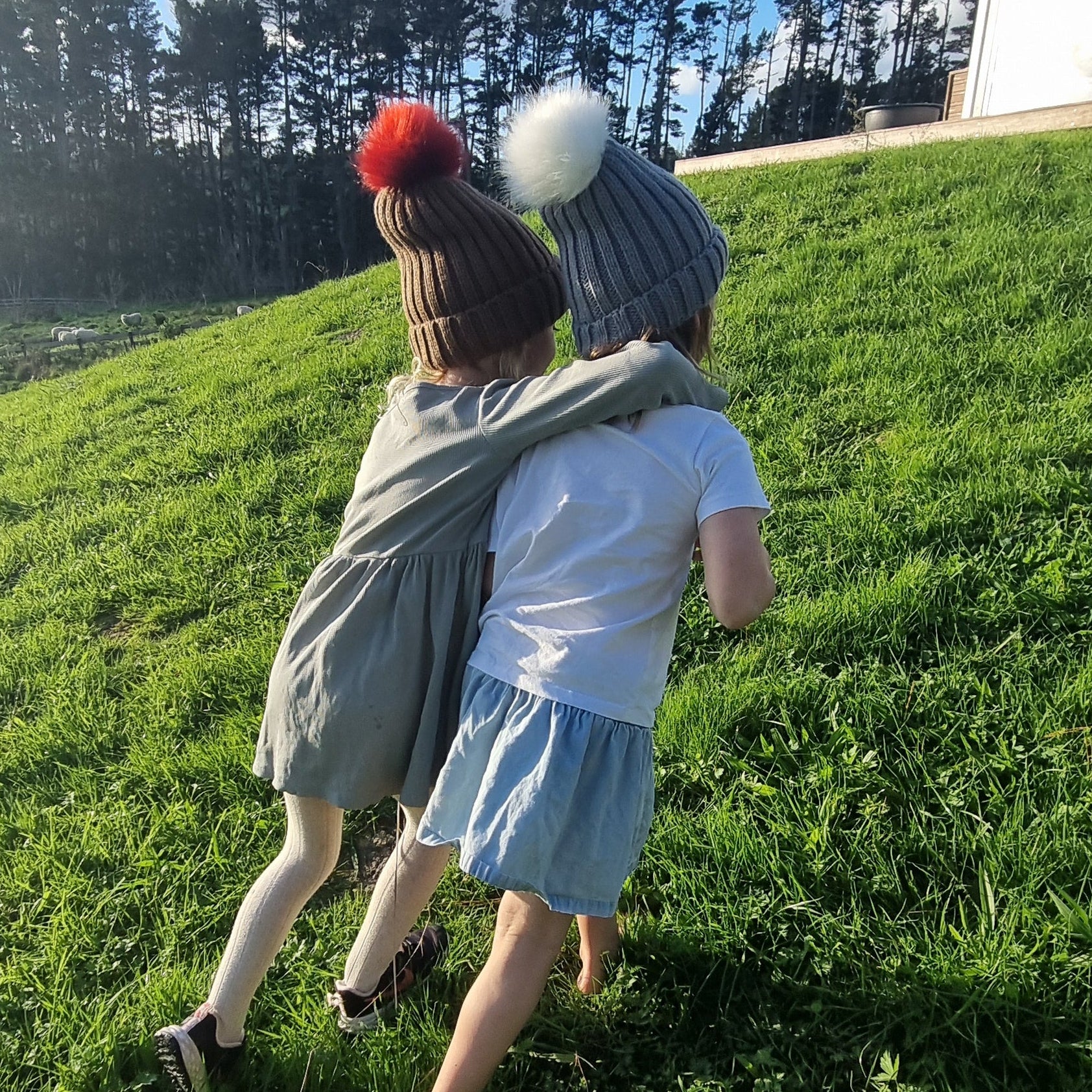 two kids with joining arms wearing Dolly & Naana beanies