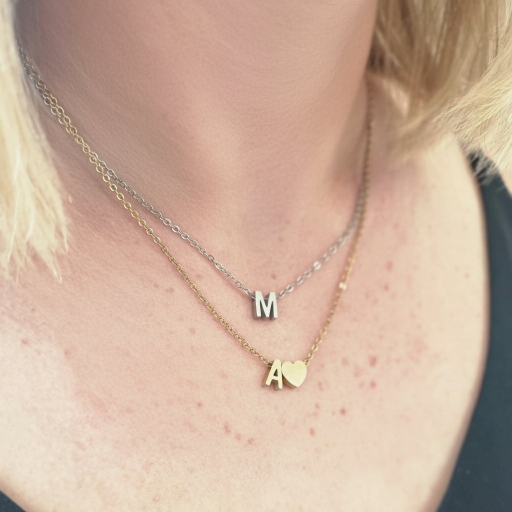 Close-up of a person wearing a delicate gold necklace with heart pendant.