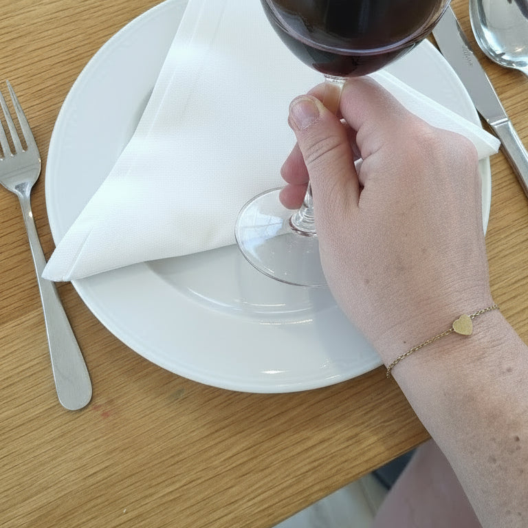 Hand with a ring on a wooden surface next to a clear plastic container