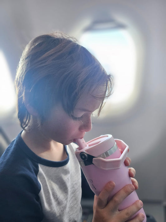 Child drinking from a pink insulated stainless steel drink bottle for kids – Dolly & Naana