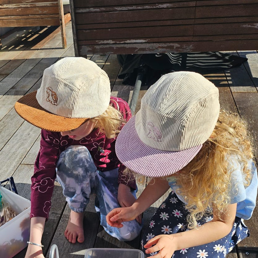 Two children playing with toys on a wooden deck